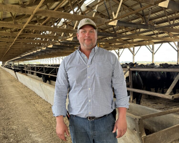 Austin Arndt poses in his cattle barn where he raises sustainable beef
