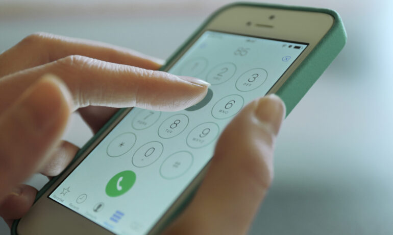 Finger touch number on smartphone to make a call, close up